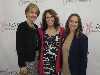 Dr. Cappello between fellow advocates at the Are You Dense? backdrop