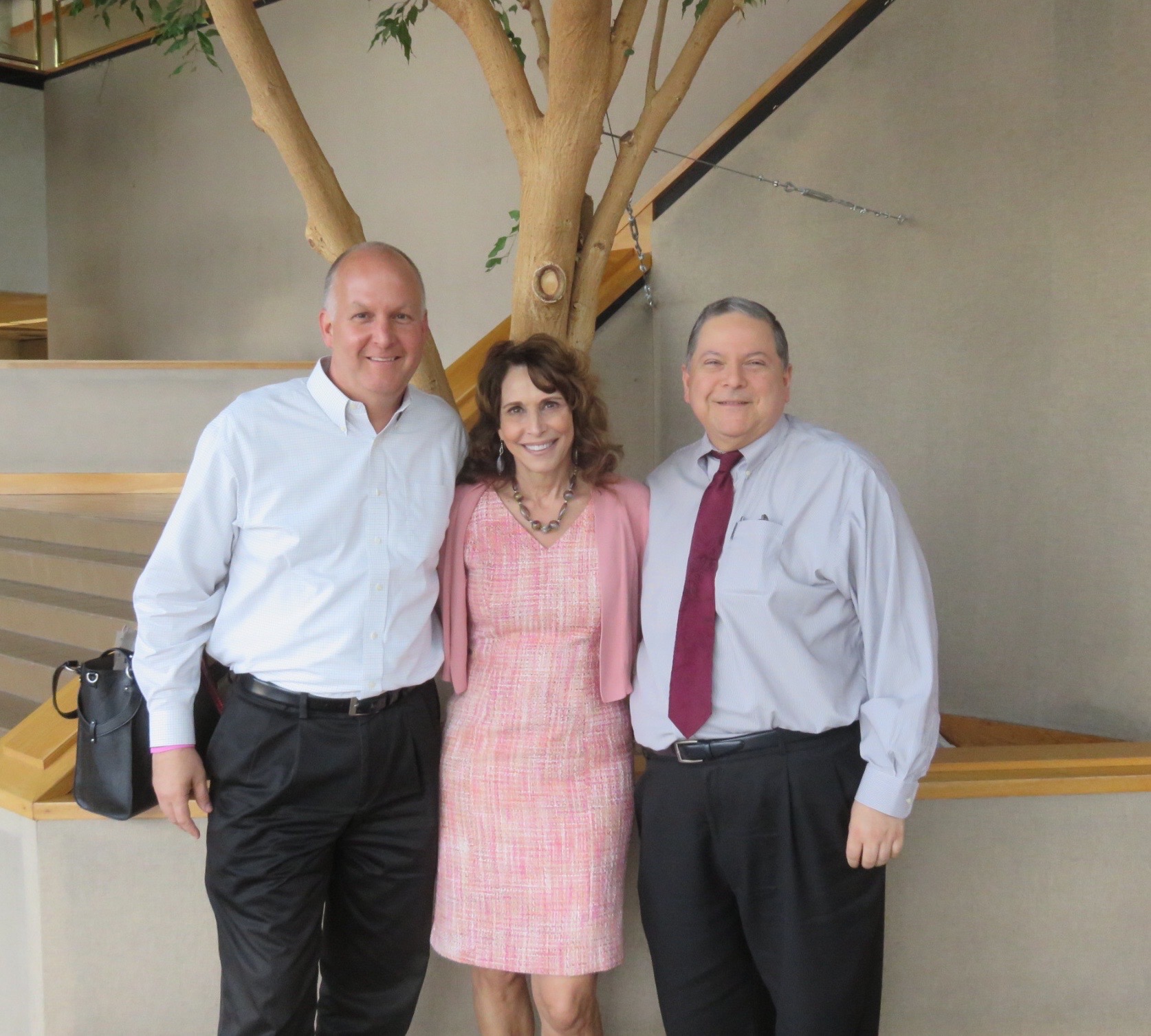 Dr. Cappello standing between Merced city leaders in a building atrium
