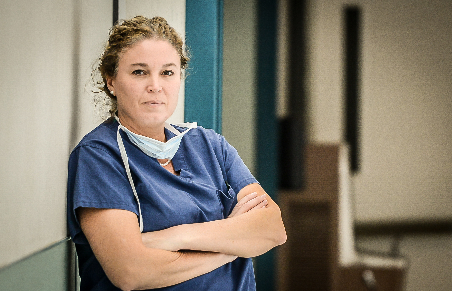 Dr. Beth Sieling in surgical scrubs, arms crossed