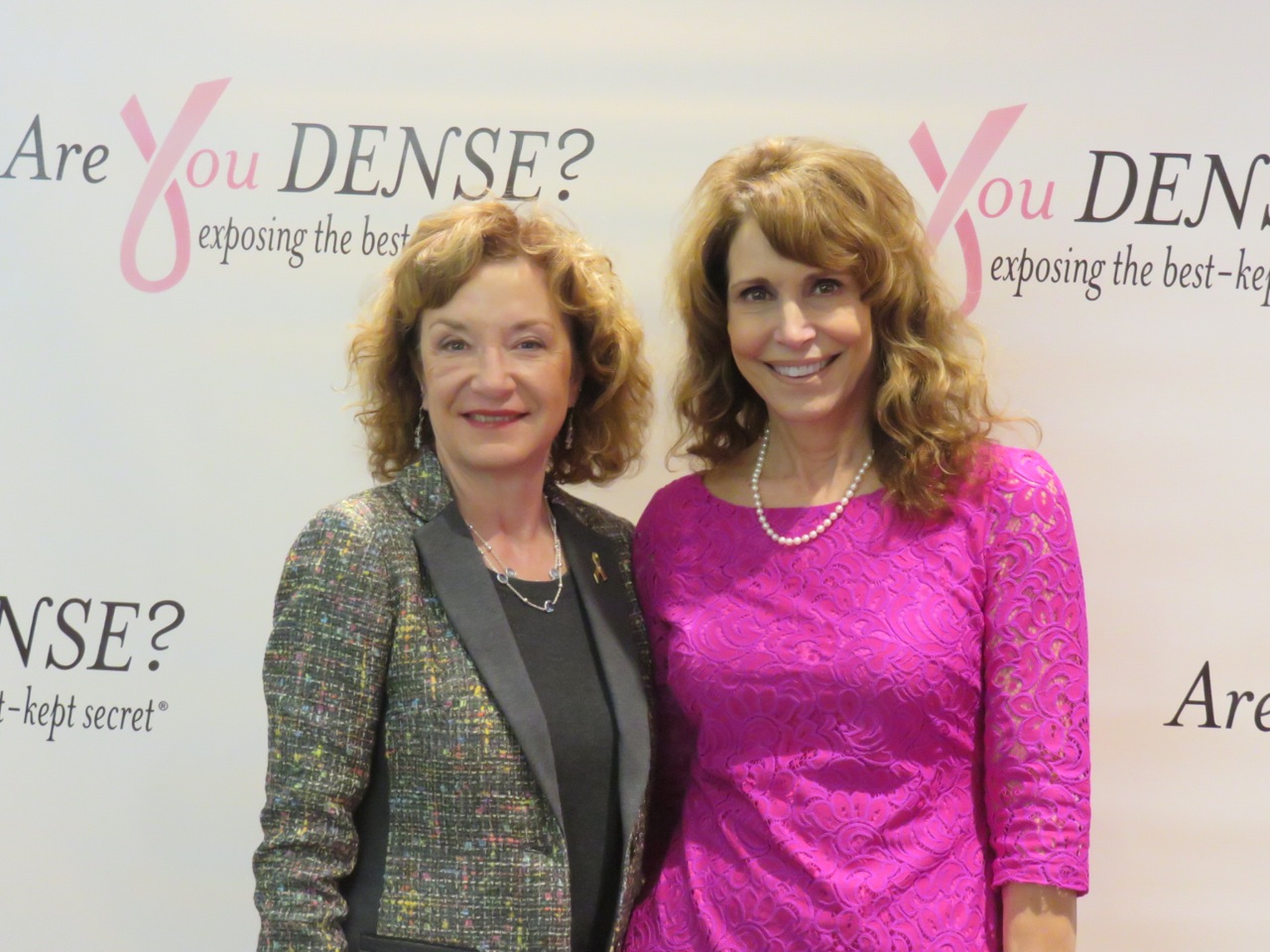Dr. Jean Weigert and Dr. Nancy Cappello in front of an Are You Dense? backdrop