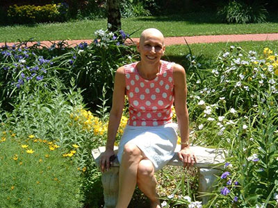 Nancy Cappello seated on a garden bench, June 2004