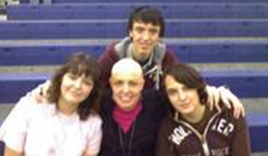 Brenda with three young people on bleachers