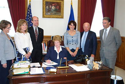 Governor Jodi Rell signing Connecticut's 2009 breast density bill, surrounded by advocates and legislators