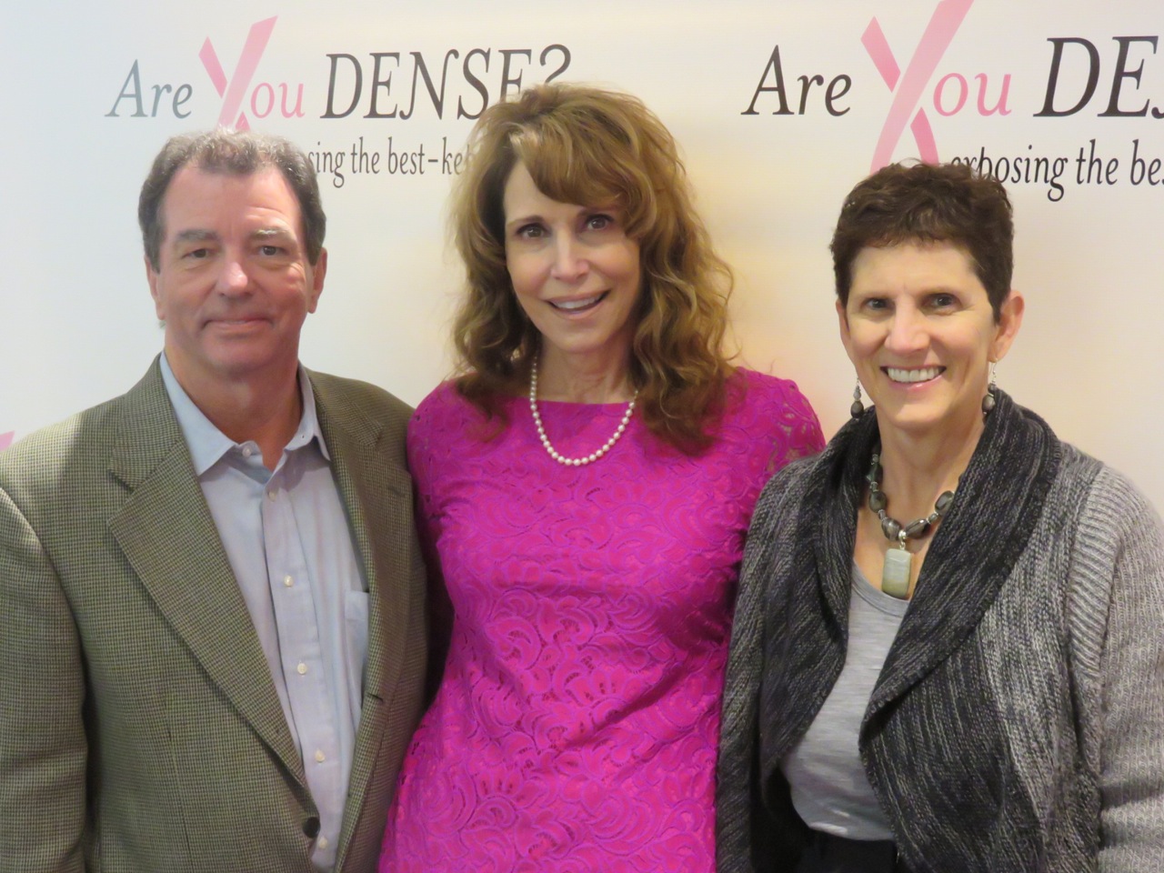 Dr. Cappello with two conference attendees in front of an Are You Dense? backdrop