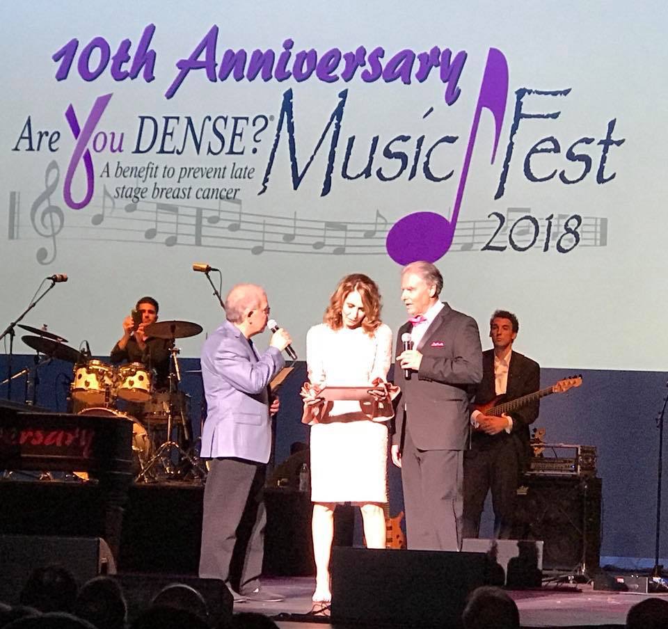 Joe and Nancy Cappello on stage under the 10th Anniversary Are You Dense? MusicFest 2018 banner