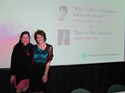 Dr. Cappello and Dr. Silber in front of a screen announcing their talks at the Hospital of Saint Raphael