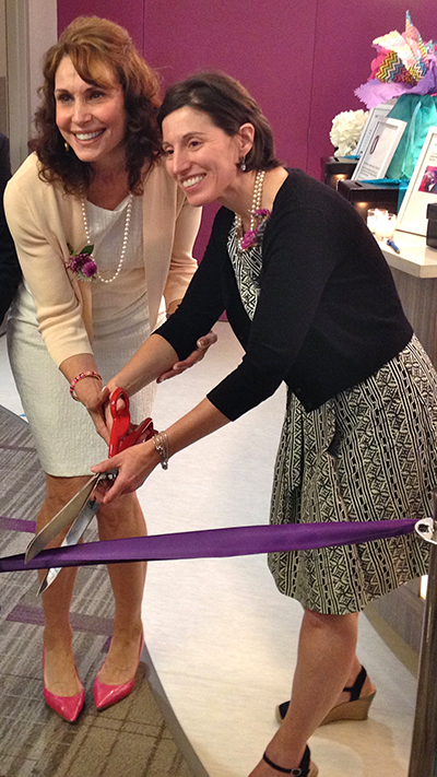 Dr. Cappello and Dr. Elise Berman cutting a purple ribbon with large red scissors