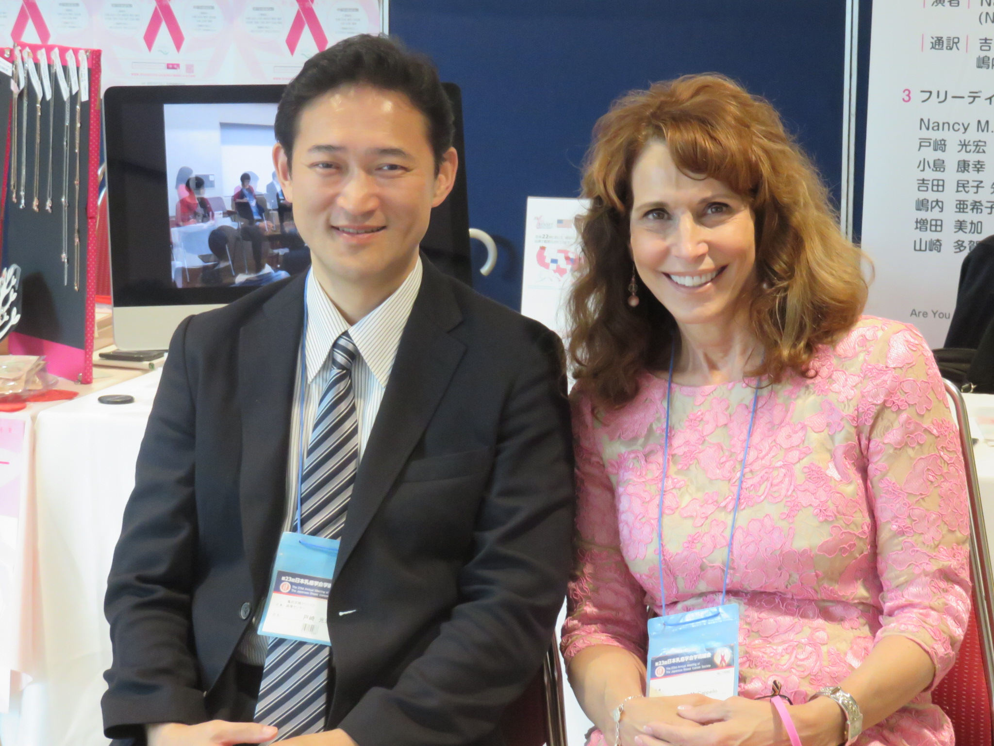 Dr. Tozaki and Dr. Cappello seated at a conference booth