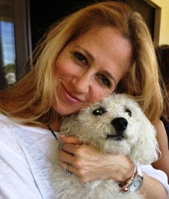 Antonia hugging a small white dog