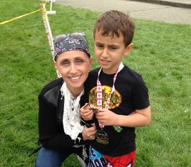 Michelle in a head scarf with a young boy at an outdoor event