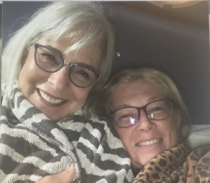 Deb and a friend, both in glasses, smiling cheek to cheek